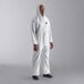 A man wearing a white Cordova Defender II coverall with elastic wrists and a hood.