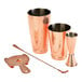 A Barfly copper cocktail kit on a table with copper glasses and a spoon.