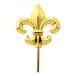 A gold-plated cocktail pick with a gold fleur de lis on top.