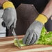 A person cutting celery on a cutting board with an Armor Guys Kyorene Pro cut-resistant glove.