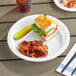 A sandwich and chips on a Choice white plastic plate.