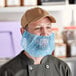 A man wearing a blue beard cover over his mouth.