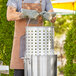 A man using a Choice aluminum stock pot with a steamer basket.