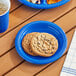 A blue Choice plastic plate with cookies and a drink on a table.