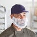 A man wearing a white disposable beard net over his beard.