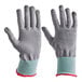 A pair of gray cut-resistant gloves with light blue cuffs and red trim, designed for food-safe use.
