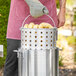 A man using a Choice aluminum stock pot to cook corn.