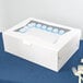 A white Baker's Lane half sheet cake box with blue frosting inside.