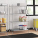 A Regency metal wire shelving unit with white and blue plastic containers on it.