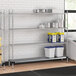 A Regency chrome wire shelving unit with a solid metal bottom shelf in a kitchen.