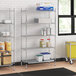 A Regency metal wire shelving unit in a kitchen with food containers on the shelves.