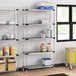 Regency galvanized steel shelves in a kitchen with pots and jars on them.