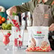 A woman pouring Dole Chef-Ready Cuts IQF Sliced Strawberries into a blender on a counter.