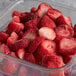 A clear plastic container of Dole Chef-Ready Cuts IQF sliced strawberries.