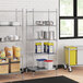 A Regency metal wire shelving unit with a solid metal bottom shelf holding containers.