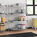 Regency shelving unit in a professional kitchen with white and blue containers on the shelves.