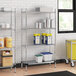 A Regency chrome wire shelving unit with a solid galvanized steel shelf holding blue and yellow containers.