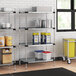 Regency galvanized steel shelves in a kitchen with food containers and buckets on them.