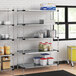 Regency galvanized steel shelving in a school kitchen with food on the shelves.