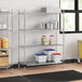 A Regency chrome wire shelving unit in a kitchen with white plastic containers on the bottom shelf.