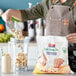 A woman pouring Dole Chef-Ready Cuts IQF Sliced Bananas into a blender.