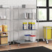 A Regency chrome wire shelving unit in a kitchen with white and blue plastic containers on the shelves.