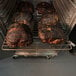 A rack of meat cooking in a SmokinTex 1500-C Pro Series Commercial Electric Smoker.