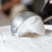 A person using a metal scoop to scoop Pitaya Foods Organic Coconut Sorbet.