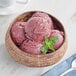 A bowl of Pitaya Foods Organic Acai Sorbet topped with red berries and mint.