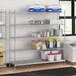 A stainless steel wire shelf kit with solid shelves holding food containers.