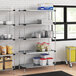 Regency galvanized steel shelves in a professional kitchen with food items on them.