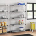 Regency galvanized steel shelves in a school kitchen with food items on them.