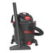 A black and red Shop-Vac wet vacuum with a hose.
