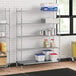 A metal Regency wire shelving unit in a kitchen with food on the shelves.