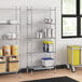 A Regency chrome wire shelving unit with a solid galvanized steel bottom shelf in a kitchen.