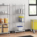 A stainless steel wire shelving unit with solid stainless steel bottom shelves holding jars of food.