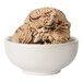 A bowl of Tillamook Coffee Almond Fudge ice cream with chocolate and nuts.