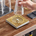 A hand holding a glass over a Regency gold surface-mount beer drip tray.