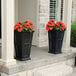 Two black Mayne Fairfield rectangular planters with orange flowers.