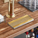 A Regency PVD gold metal surface-mount beer drip tray on a bar counter.