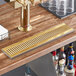 A Regency PVD gold surface-mount beer drip tray on a bar counter.