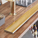 A Regency PVD gold finish surface-mount beer drip tray on a bar counter.