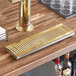 A Regency surface-mount beer drip tray with a PVD gold finish on a bar counter.