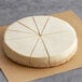 Sirabella's Pre-Cut Vegan Cheesecake with six slices cut out on a brown surface.