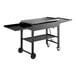 A black rectangular Backyard Pro outdoor griddle on a metal cart with wheels.
