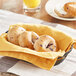 A basket filled with Original Bagel blueberry mini bagels on a table.