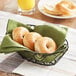 Whole wheat mini bagels in a basket on a table.