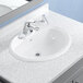 An American Standard white vitreous china drop-in sink with a faucet.