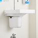 A white American Standard shroud for a wall-mount sink.