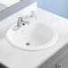 An American Standard white vitreous china drop-in sink with a faucet.